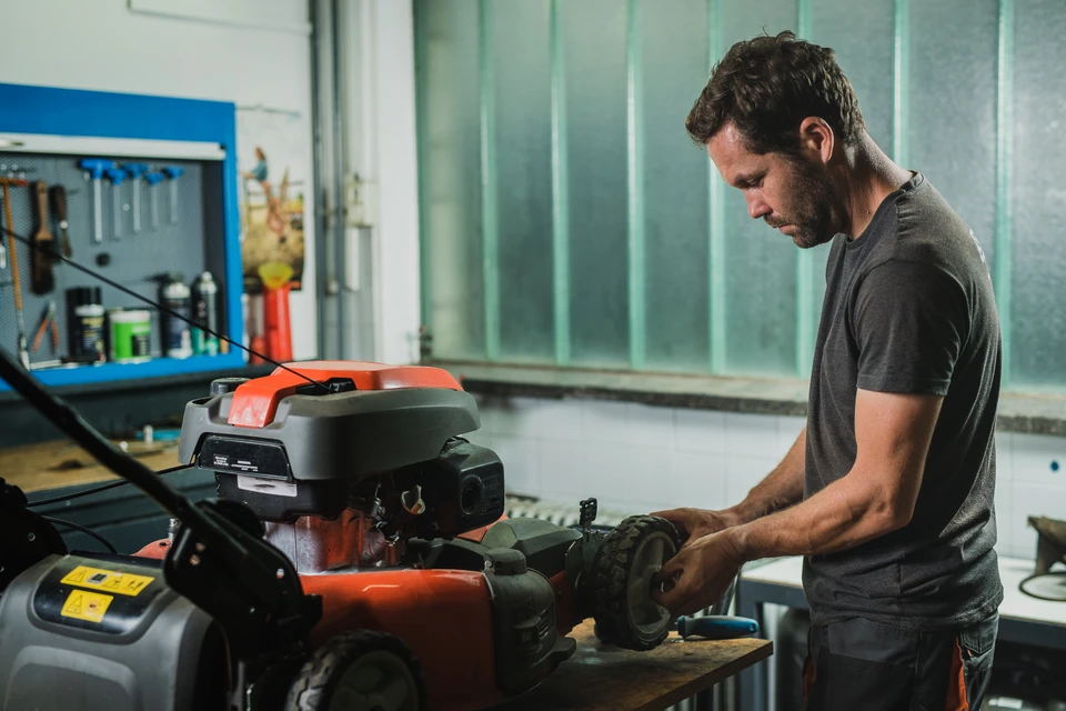 Un motard m&acirc;le fort r&eacute;pare sa moto dans le garage